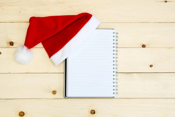 Santa hat and diary  on wooden table — Stock Photo, Image