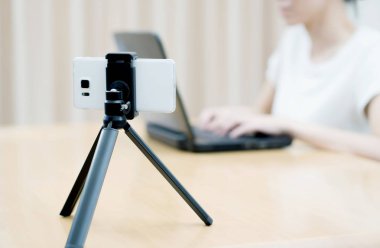 Kadın vlogger dizüstü bilgisayar kullanarak ve video çekerek görünüyor