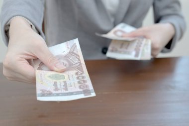 Woman is paying In cash with banknotes