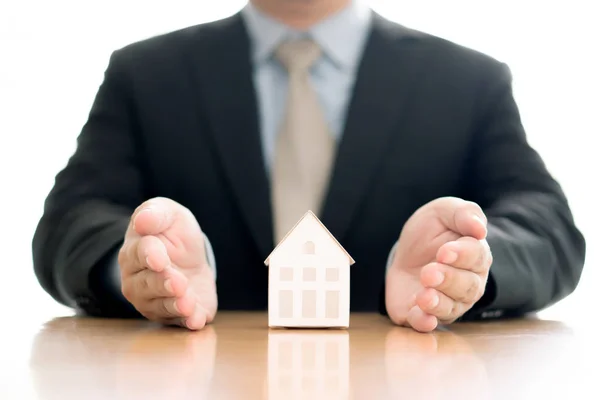 Business man hand hold the house model saving small house. — Stock Photo, Image