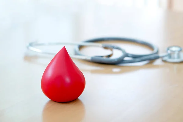 Estetoscópio e um sangue vermelho colocados em madeira — Fotografia de Stock