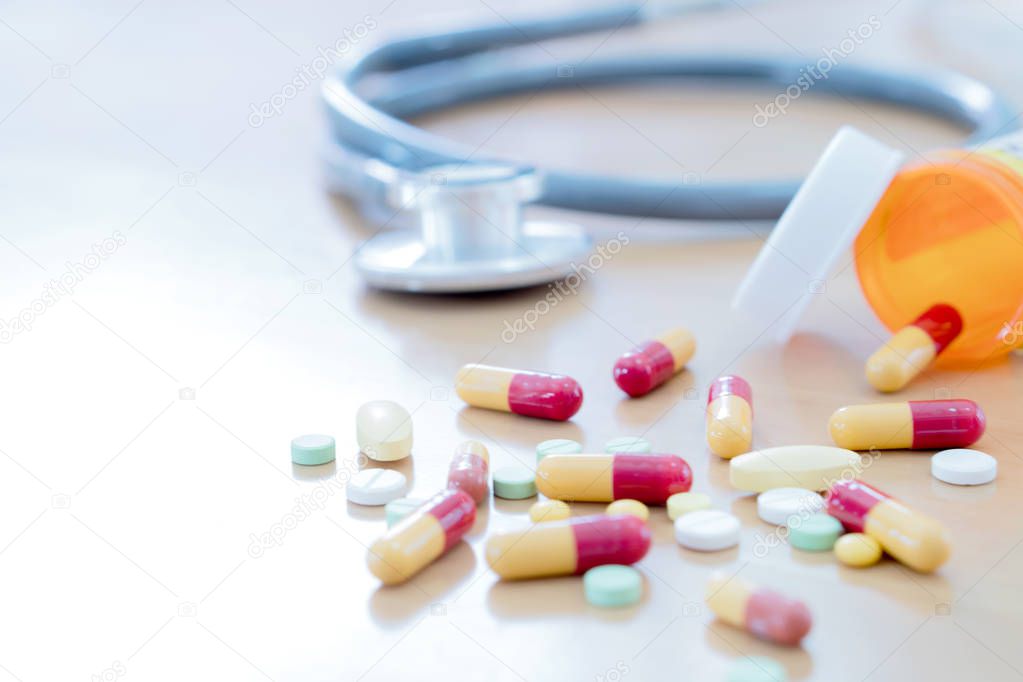 Medical concept with pills and stethoscope on table wooden