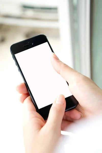 Donna con moderno telefono cellulare in mano che tocca uno spaventapasseri bianco — Foto Stock