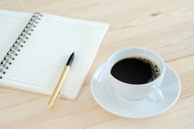 defter kalem ve ahşap masa kahve fincan