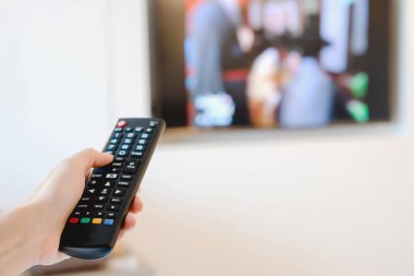 Tv'de uzaktan kumandayı gösteren bir el