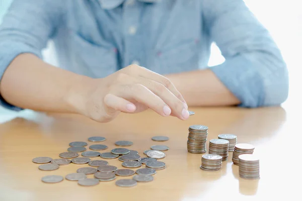 Man counting stacks of coins on table — Stock Photo, Image