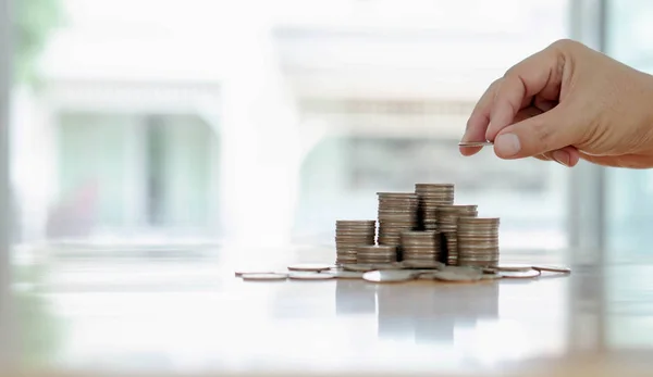 Hand giving coins into stack, business and finance concept — Stock Photo, Image