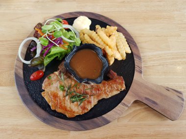 Biber sosu ve ahşap t üzerinde patates kızartması ile domuz pirzolası biftek