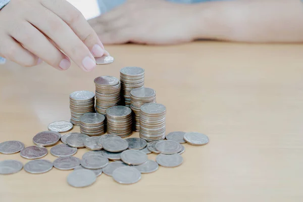 Businessman hand coins in finger and row stacks them — Stock Photo, Image