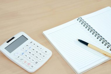 defter, kalem ve ahşap üzerine hesap makinesi