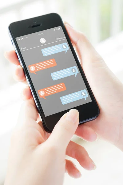 Mujer mano sosteniendo el teléfono con mensajero aplicación en la pantalla —  Fotos de Stock