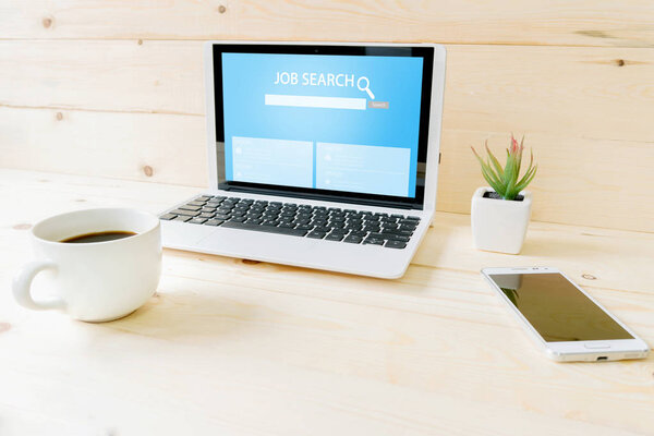 Online job search engine on laptop  on wood table