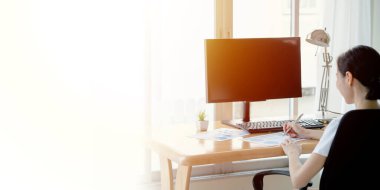 Kadınlar evde bilgisayar ve kağıt grafikleriyle çalışıyorlar..