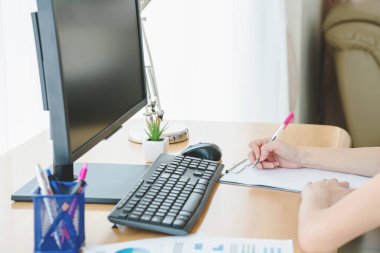 Kadınlar evde bilgisayar ve kağıt grafikleriyle çalışıyorlar..