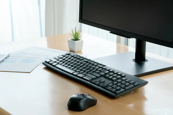 Wireless mouse and keyboard set on top of a wooden office desk, work from home concept