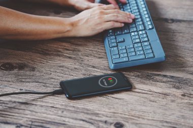 USB şarj cihazını akıllı telefona bağlayan adam