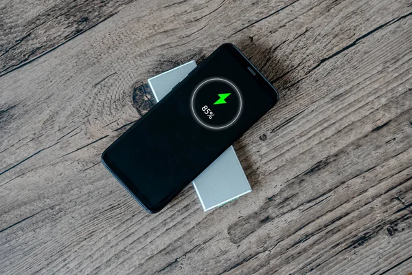 Wireless charging of smartphone on restaurant table, concept