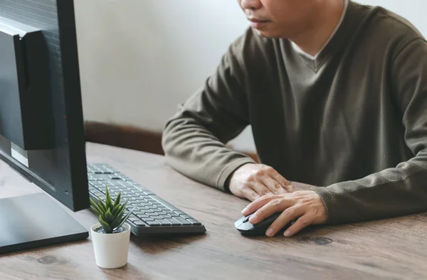 Man working with desktop computer in office closeup of hand clicking mouse, business concept