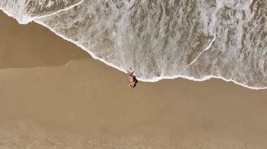 Baş döndürücü bir hava aracı, kumlu bir sahilde huzur içinde yatan hamile bir kadını yakalıyor. Görüntüler anneliğin ve doğanın güzelliğini ve huzurunu vurguluyor..