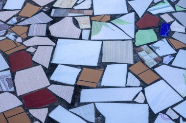 Unique and artistic design of a house roof floor, decorated with a textured background of colorful broken floor tiles in various shapes and sizes, perfect for creative projects.