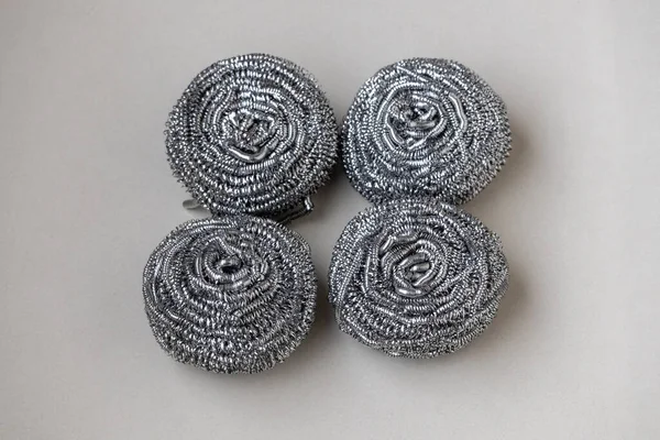 Beyaz arka planda dört yeni çelik yün temizleyici. Mutfak gereçleri ve yemek malzemeleri için mükemmel..