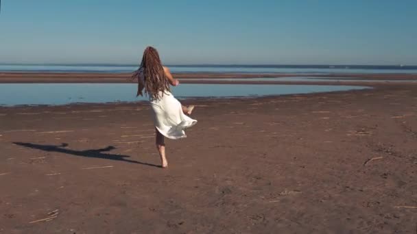 Ung kvinna dansar på stranden — Stockvideo