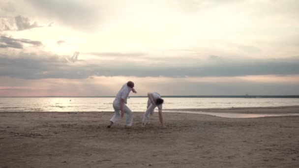 Dos hombres practicando capoeira en la playa — Vídeo de stock