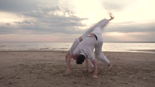 Dwóch mężczyzn praktykujących capoeira na plaży — Wideo stockowe
