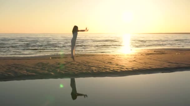 Mujer joven en vestido blanco bailando en la playa — Vídeos de Stock