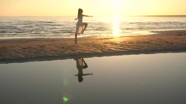 Mujer joven en vestido blanco bailando en la playa — Vídeos de Stock