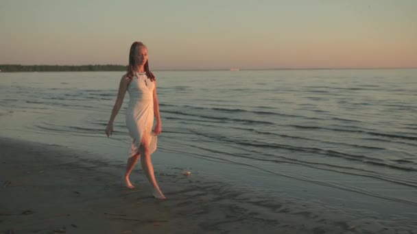 Молодая женщина, гуляющая по пляжу — стоковое видео