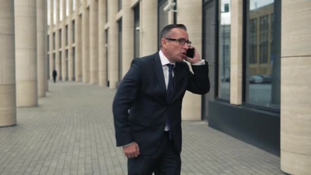 Сердитий бізнесмен говорить на мобільному телефоні — стокове відео
