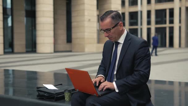 Άνθρωπος με επίσημο κοστούμι λειτουργεί σε laptop — Αρχείο Βίντεο