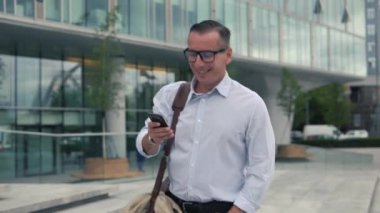 Yürüyüş ve smartphone kullanarak adam