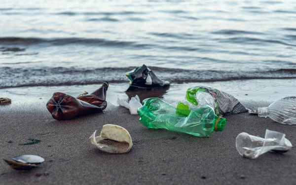Plastik çöpler plajda yatıyor.