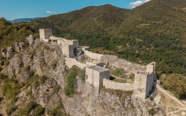 Gürcistan 'daki orman dağlarıyla çevrili kayalık bir tepedeki Modinakhe Kalesi' nin insansız hava aracı görüntüsü.