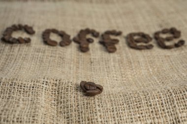 Kahve çekirdeği harfler kendir arka plan üzerinde.