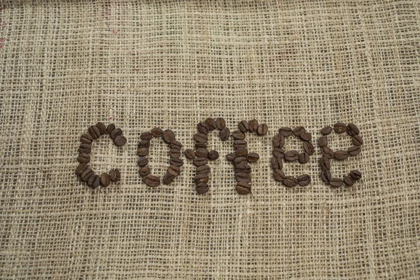 Kaffeebohnen Briefe Auf Hessischem Hintergrund — Stockfoto