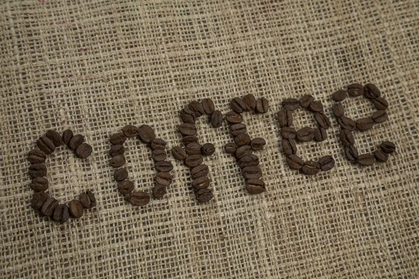 Coffee Bean Letters Tegen Een Achtergrond Van Hessiaan — Stockfoto