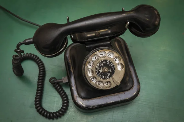 Vintage old telephone on green table background