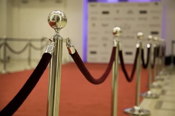 Red carpet with barriers and velvet ropes.