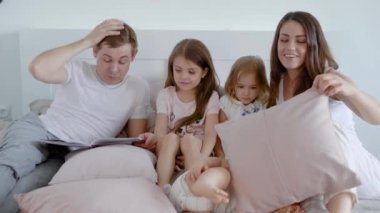 Mutlu aile yatak çocuk ile vakit geçirmek ve kitap okuma