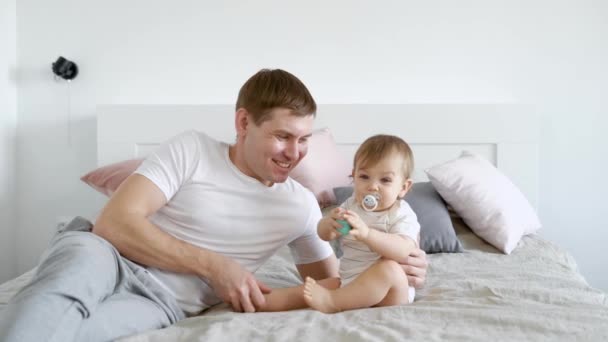 Padre acostado en la cama con el bebé — Vídeo de stock