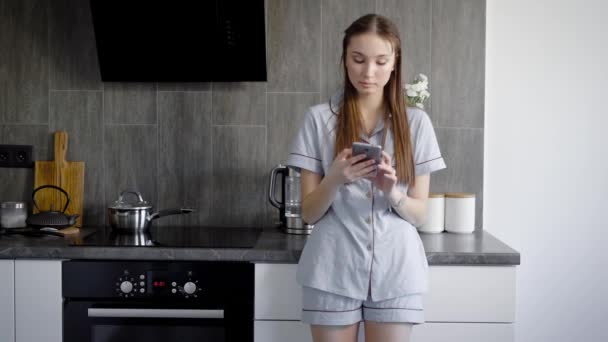 Hermosa mujer joven de pie en la cocina — Vídeos de Stock