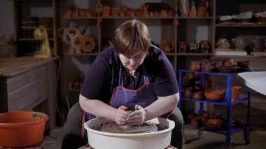 Oturma ve clayware atölye potters direksiyona şekillendirme önlük giyen kadın Efendi