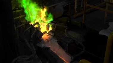 Metalurji üretim. Erimiş metal fırın yağıyor, sıcak sıvı çok tehlikelidir.