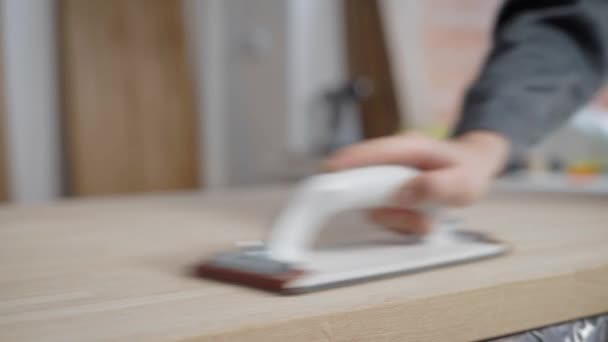 Foto ravvicinata di un falegname professionista che carteggia una tavola di legno con carta vetrata in un'officina . — Video Stock