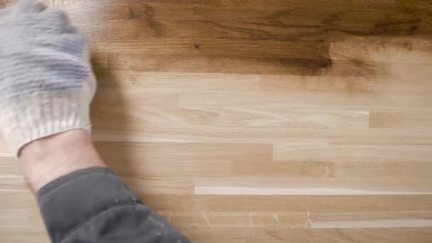Záběr z výšky stavitelů rukou pečlivě vyrovnávací olej na hladké kus dřeva s látkou. — Stock video