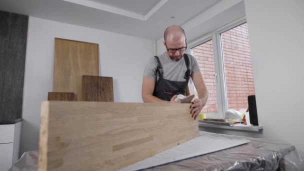 Professionele timmerman zorgvuldig werken met zijden van houten bord. — Stockvideo