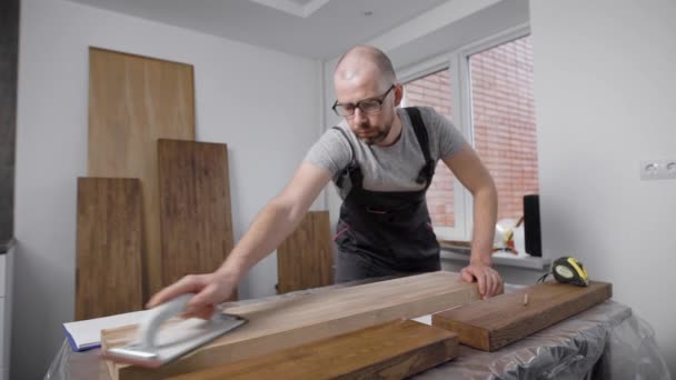 Professional in a uniform sanding the side of a the deck. — Stock Video